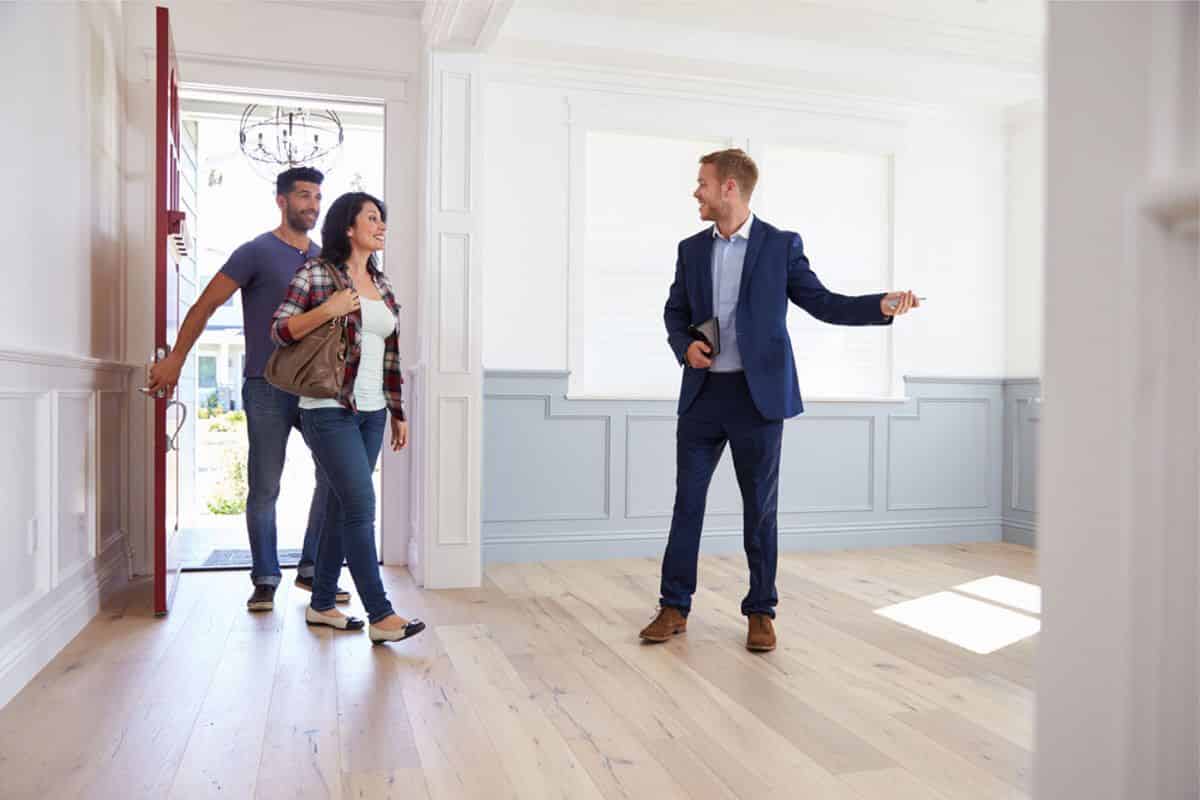 un agent immobilier qui fait visiter un appartement à un couple