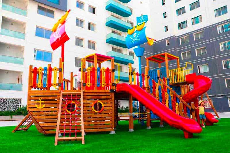 Des enfants qui s'amusent dans une aire de jeux à la résidence Belle colline Bessa Promotion
