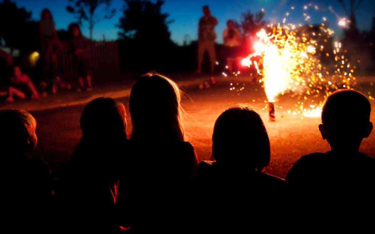 groupe d'enfants fetant le nouvel an et assistent a une scene de feu d'artifice