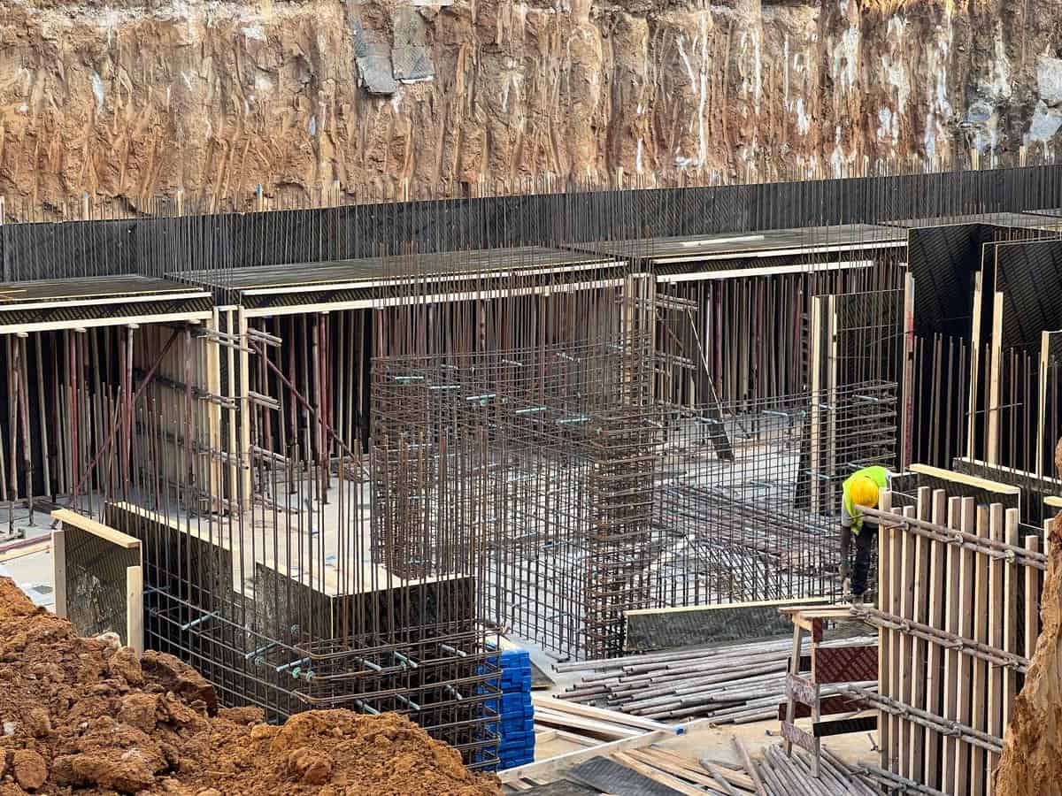 Mise en place des cages d'armature et des systèmes de coffrage en préparation du coulage des fondations en béton Mise en place des cages d'armature et des systèmes de coffrage en préparation du coulage des fondations en béton